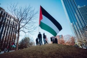 A group of people standing on top of a hill with a palestinian flag.